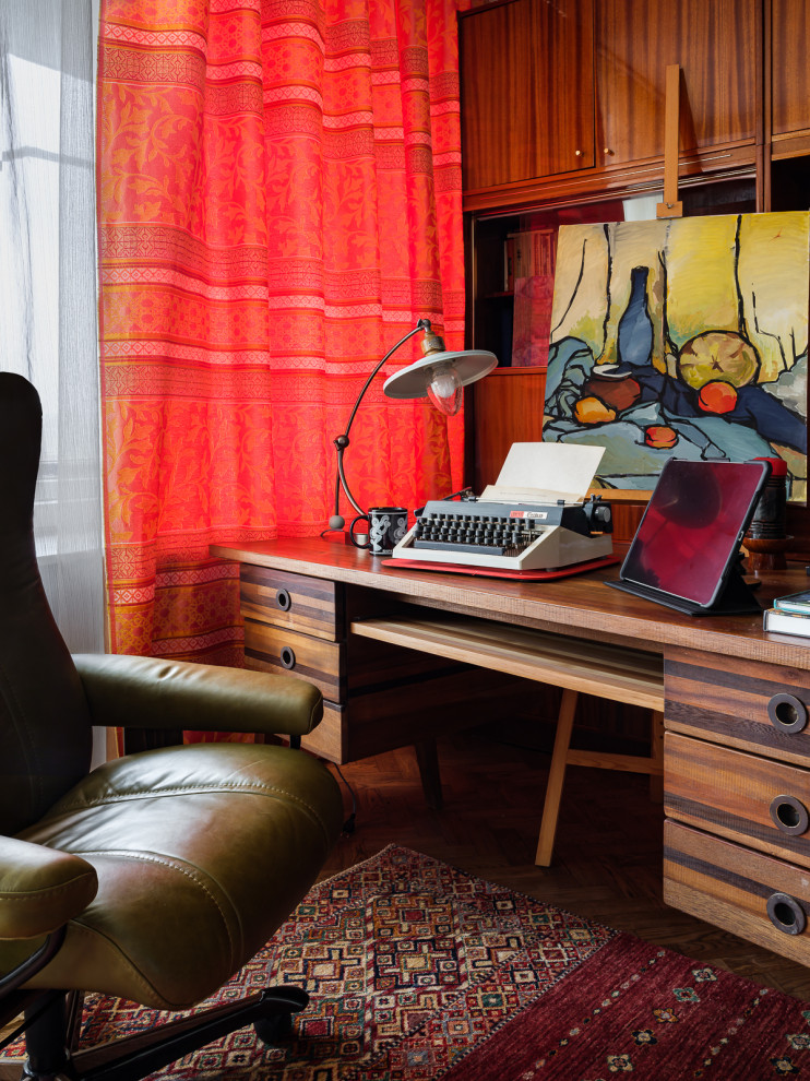 Cette image montre un petit bureau bohème avec un mur multicolore, parquet foncé, aucune cheminée, un bureau indépendant, un sol marron et du papier peint.
