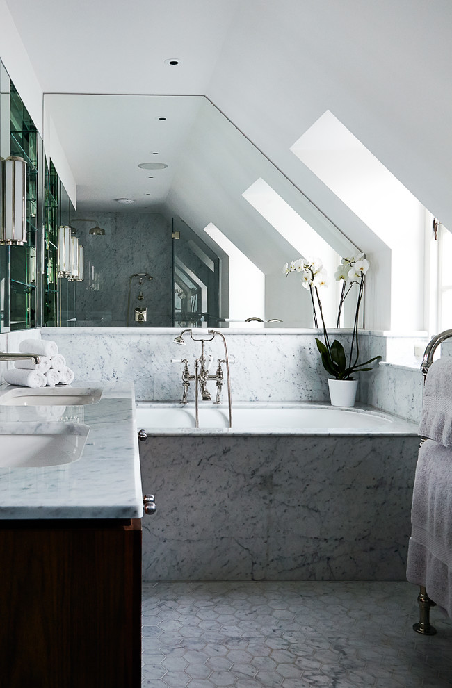 This is an example of a transitional master bathroom in London with an undermount sink, an undermount tub, white walls, marble benchtops, marble floors and marble.