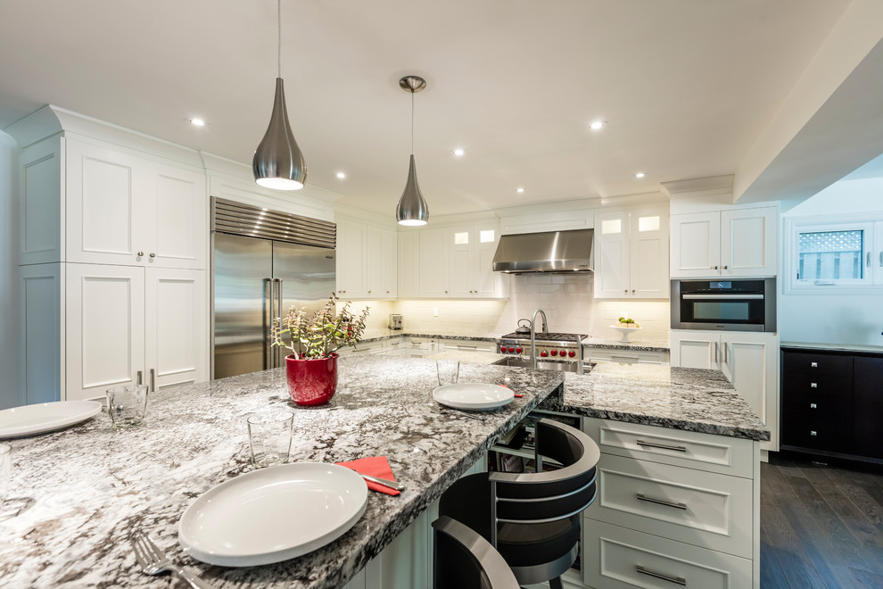 Inspiration for a mid-sized transitional brown floor kitchen remodel in Toronto with white cabinets, stainless steel appliances and an island