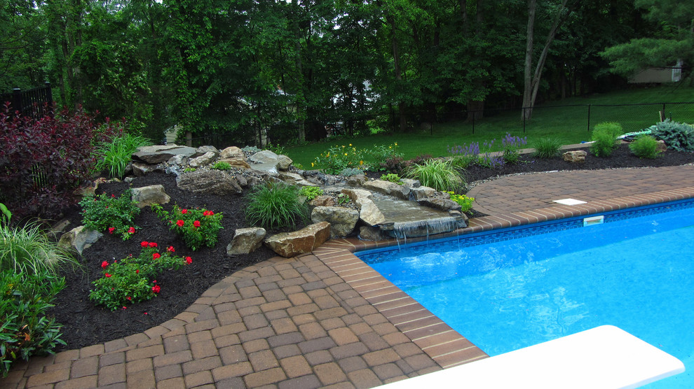 Mid-sized country backyard full sun garden in New York with a water feature and concrete pavers for summer.
