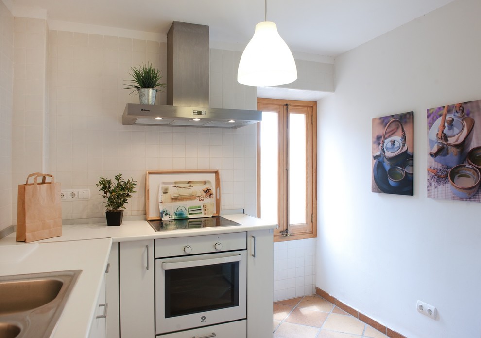 Ejemplo de cocinas en L campestre de tamaño medio cerrada sin isla con fregadero de doble seno, armarios con paneles lisos, puertas de armario blancas, salpicadero blanco y electrodomésticos blancos