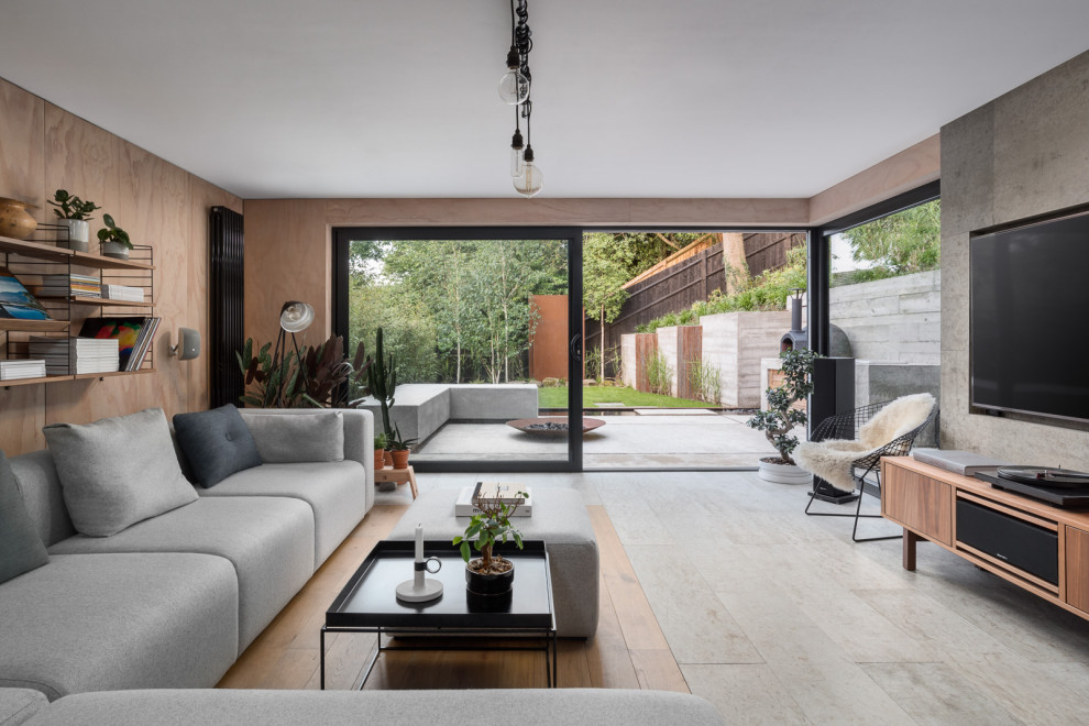 Medium sized scandi grey and brown open plan living room in Surrey with brown walls, concrete flooring, a built-in media unit, grey floors, panelled walls and feature lighting.