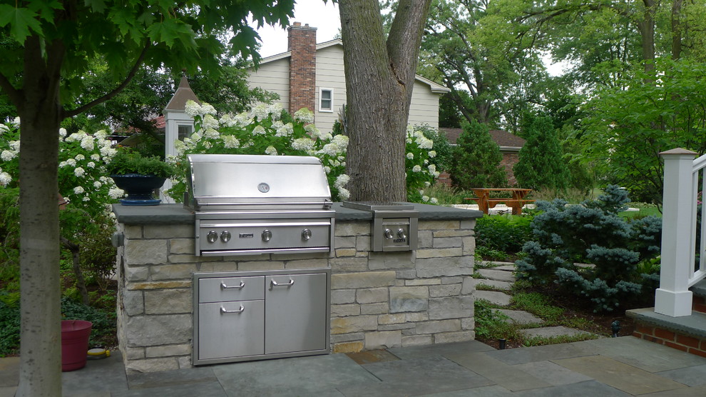 Inspiration for a large country backyard patio in Chicago with an outdoor kitchen, natural stone pavers and no cover.