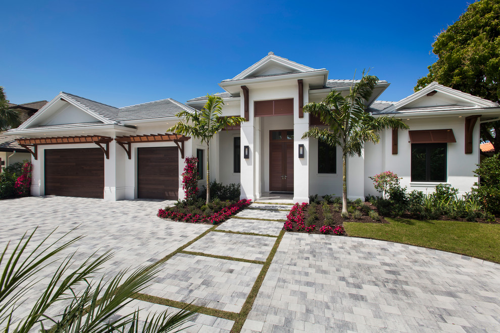 Tropical one-storey stucco white house exterior in Miami with a tile roof.