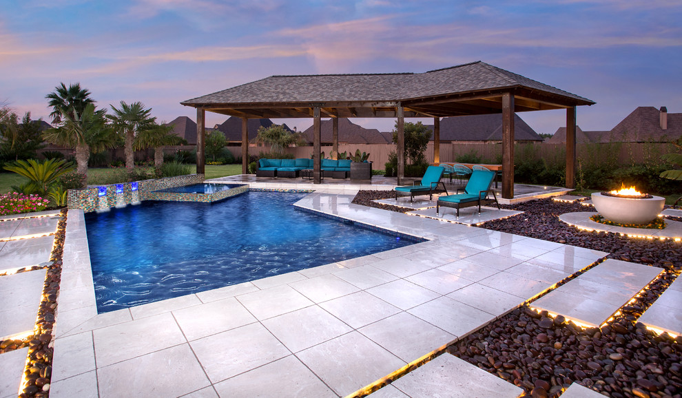 Photo of a contemporary backyard custom-shaped pool in New Orleans with a hot tub and tile.