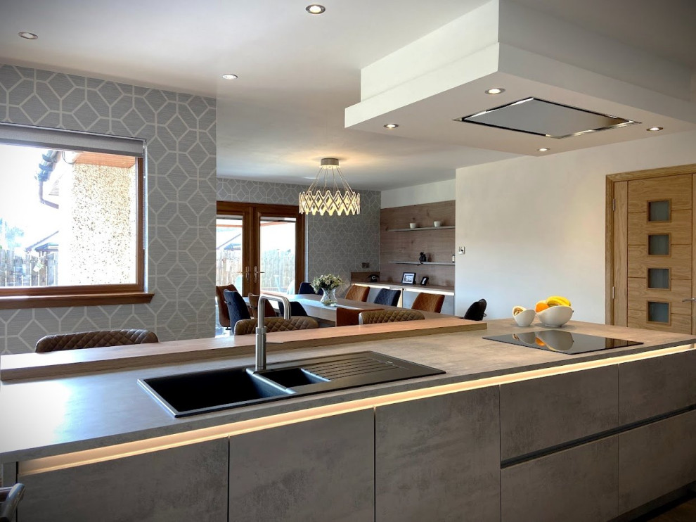 Inspiration for a medium sized contemporary single-wall kitchen/diner in Other with a double-bowl sink, flat-panel cabinets, grey cabinets, concrete worktops, black appliances, an island and beige worktops.
