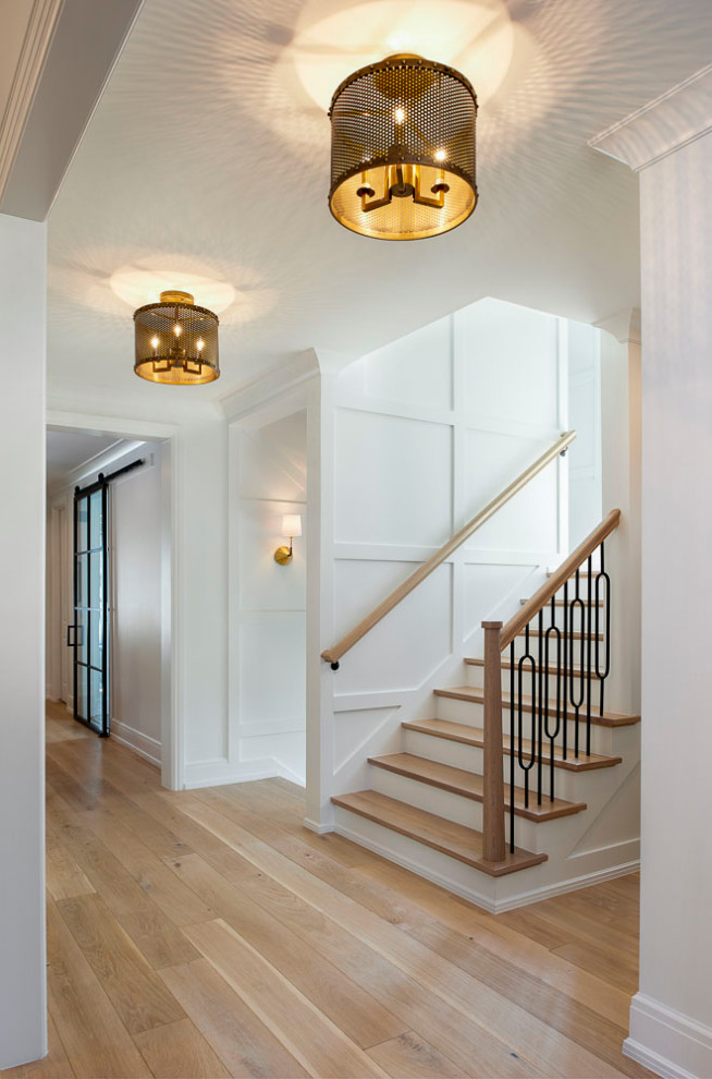 Idée de décoration pour un grand escalier droit craftsman avec des marches en bois, des contremarches en bois, un garde-corps en bois et boiseries.