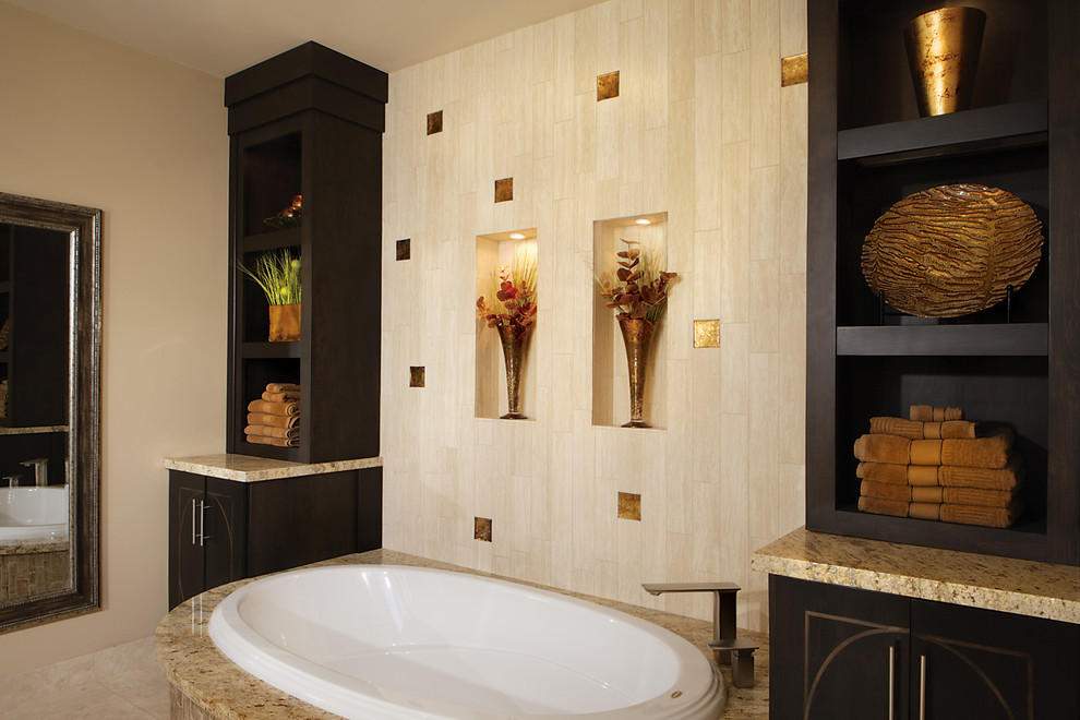 Photo of a mid-sized transitional master bathroom in Phoenix with a vessel sink, flat-panel cabinets, dark wood cabinets, granite benchtops, a drop-in tub, a corner shower, a two-piece toilet, beige tile, glass tile, beige walls and travertine floors.