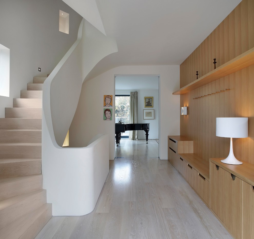 Photo of a mid-sized contemporary wood curved staircase in London with wood risers.