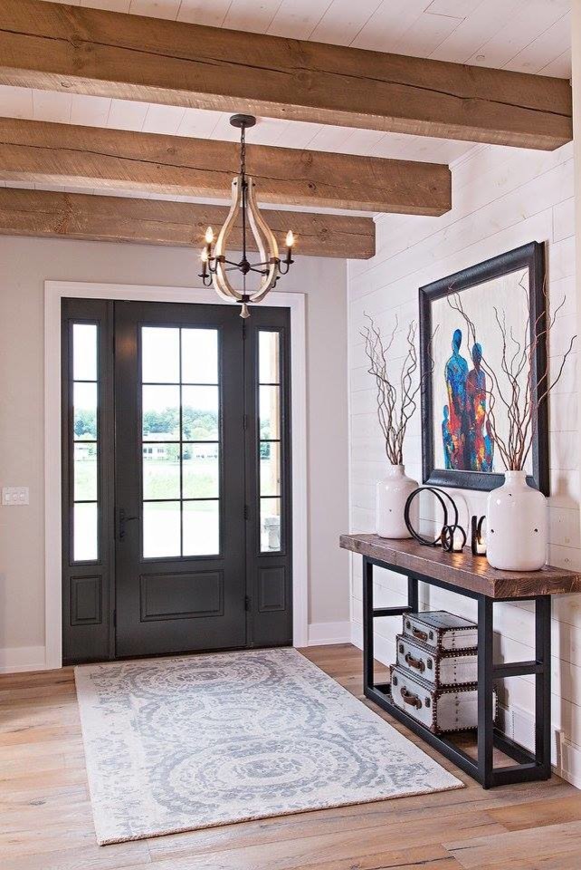 This is an example of a mid-sized country front door in Other with white walls, light hardwood floors, a single front door and a black front door.