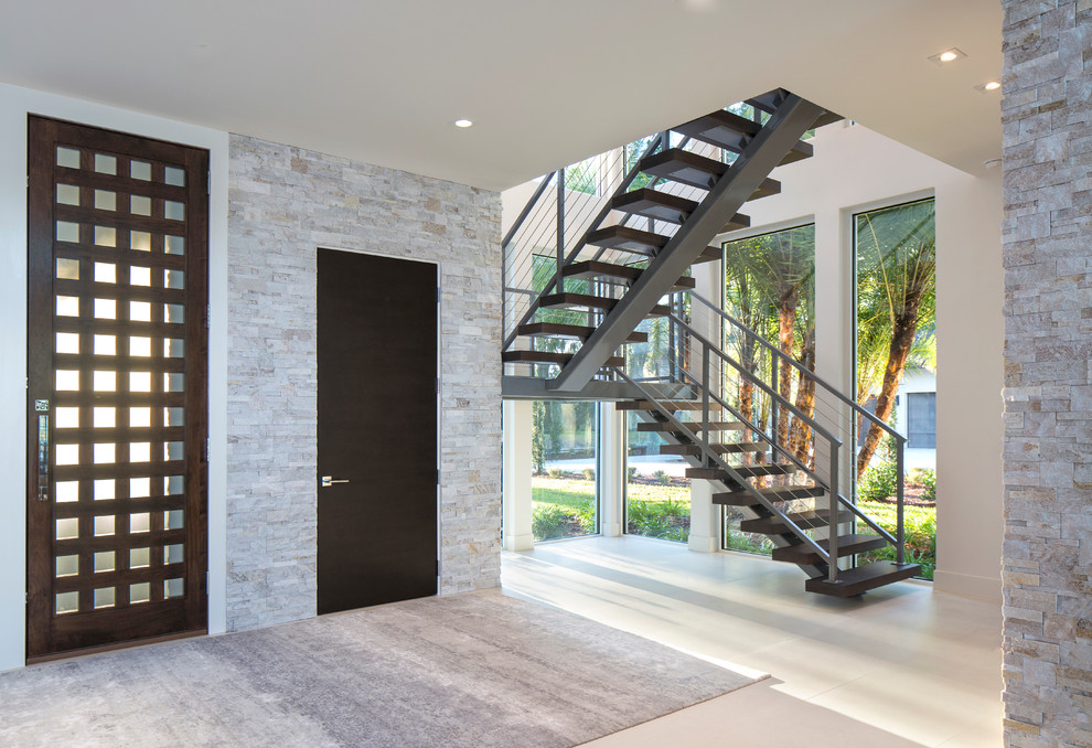 Design ideas for a large contemporary front door in Jacksonville with grey walls, light hardwood floors, a single front door and a dark wood front door.