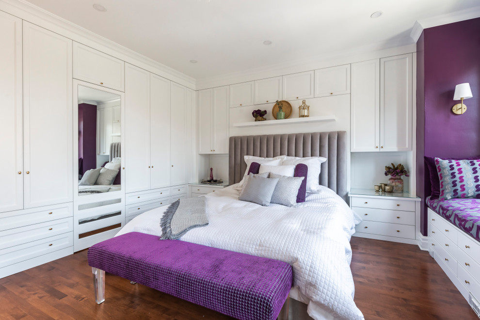 Inspiration for a large transitional master bedroom in Montreal with purple walls, medium hardwood floors, a hanging fireplace and brown floor.