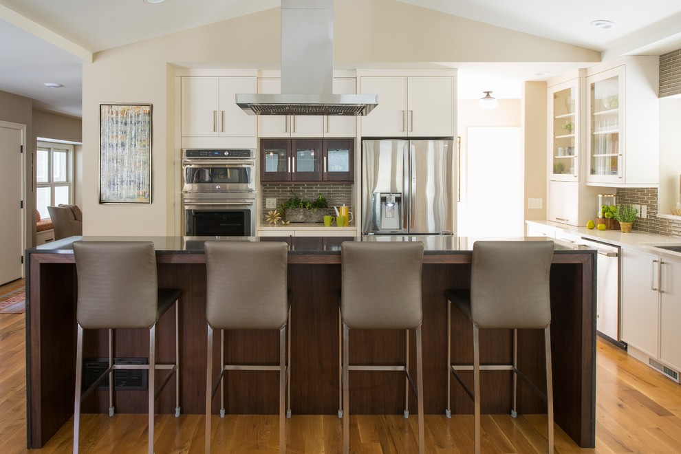 Kitchen - transitional medium tone wood floor kitchen idea in Minneapolis with white cabinets, gray backsplash, stainless steel appliances and an island