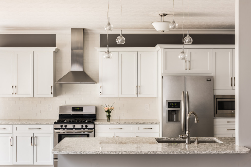 Mid-sized transitional galley vinyl floor and beige floor open concept kitchen photo with an undermount sink, recessed-panel cabinets, white cabinets, quartz countertops, white backsplash, stone tile backsplash, stainless steel appliances, a peninsula and multicolored countertops