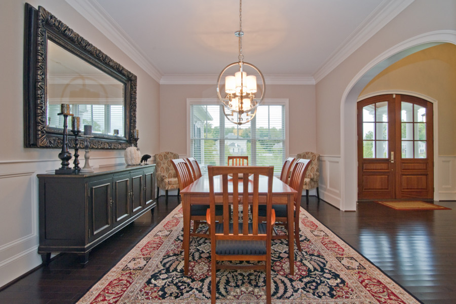This is an example of a transitional dining room in Baltimore with beige walls and dark hardwood floors.
