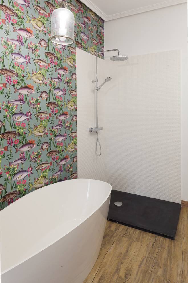 This is an example of a tropical master bathroom in Madrid with a freestanding tub, a corner shower, white tile, an open shower, multi-coloured walls and beige floor.