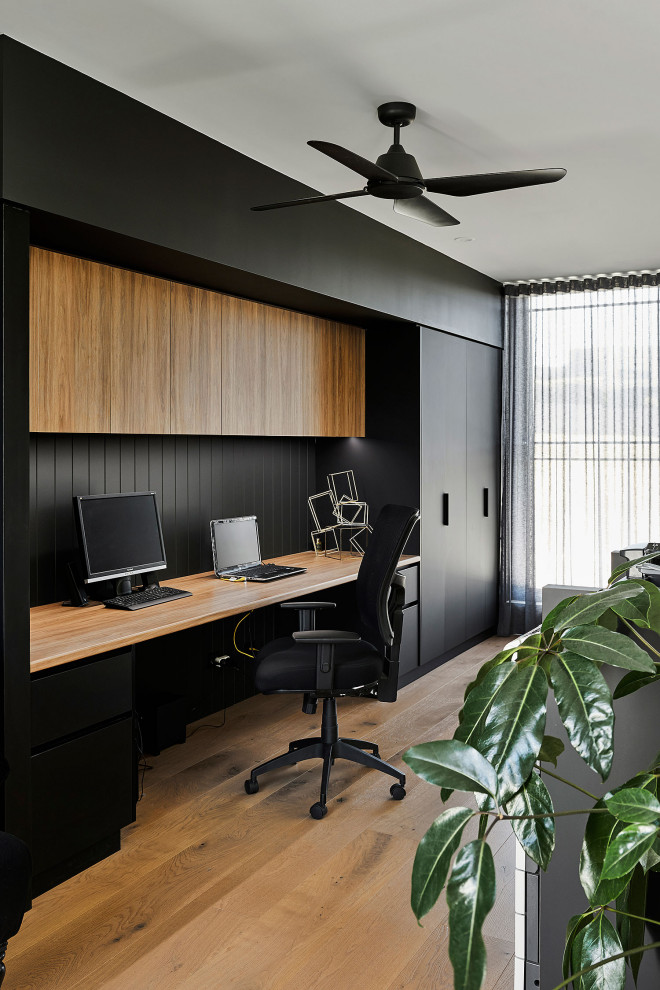 Großes Modernes Arbeitszimmer mit Arbeitsplatz, weißer Wandfarbe, braunem Holzboden, Einbau-Schreibtisch und braunem Boden in Geelong