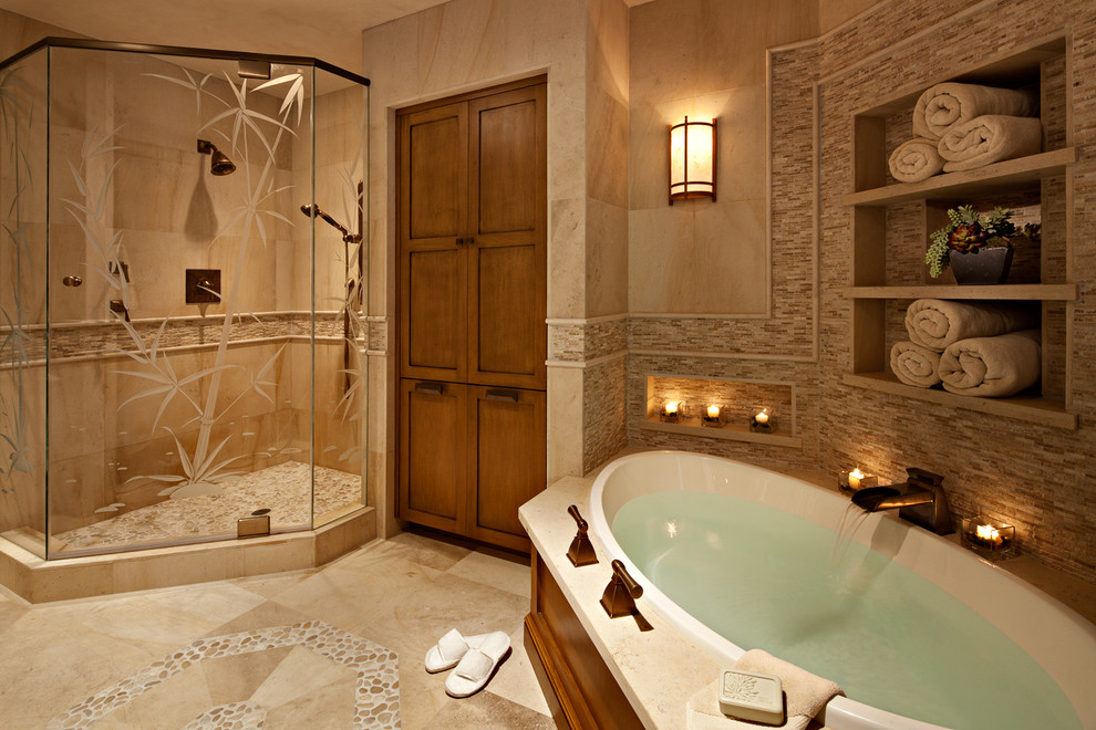 Inspiration for a mid-sized traditional master bathroom in Orange County with a drop-in tub, a corner shower, beige tile, shaker cabinets, medium wood cabinets, a two-piece toilet, stone tile, beige walls, limestone floors and an undermount sink.