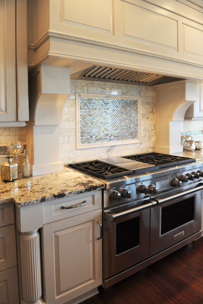 Mid-sized transitional l-shaped dark wood floor open concept kitchen photo with an undermount sink, raised-panel cabinets, white cabinets, granite countertops, white backsplash, mosaic tile backsplash, stainless steel appliances and an island