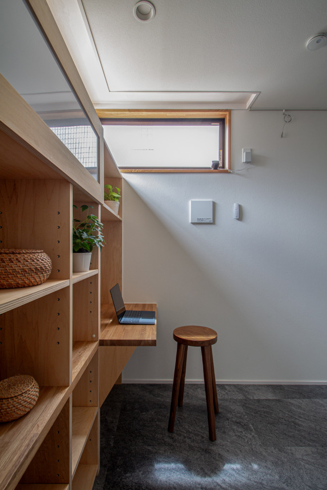 Idéer för mellanstora nordiska hemmastudior, med vita väggar, linoleumgolv, ett inbyggt skrivbord och svart golv