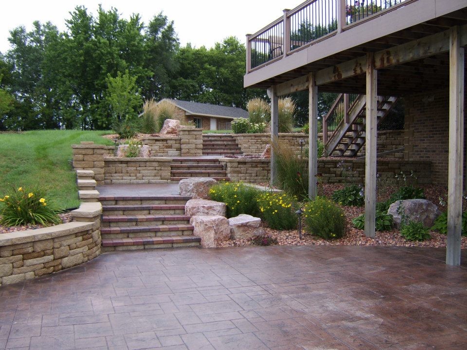 Large elegant backyard stone patio photo with no cover