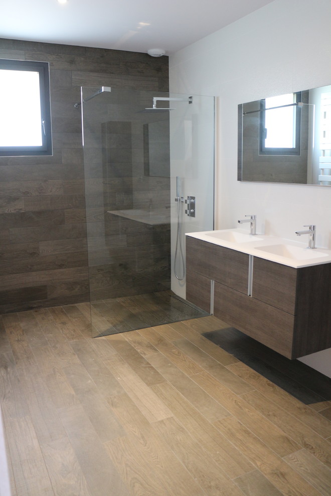 Small contemporary master bathroom in Dijon with open cabinets, medium wood cabinets, a curbless shower, brown tile, white walls, light hardwood floors, an undermount sink and soapstone benchtops.