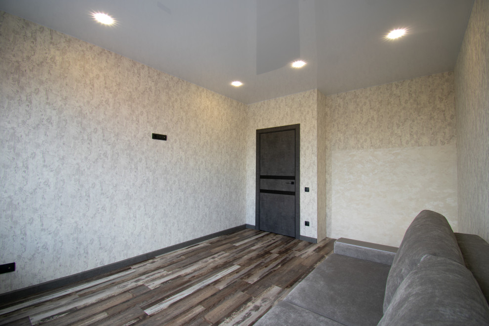 Источник вдохновения для домашнего уюта: большая гостиная комната с бежевыми стенами, полом из винила, коричневым полом и обоями на стенах