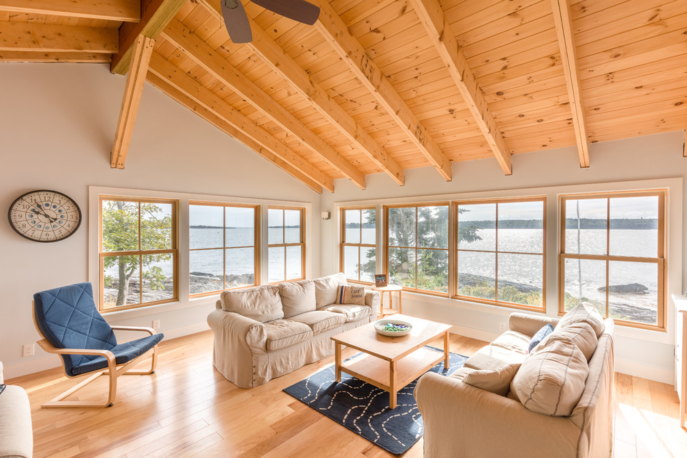 Photo of a mid-sized beach style open concept living room in Portland Maine with white walls, light hardwood floors, no fireplace and no tv.