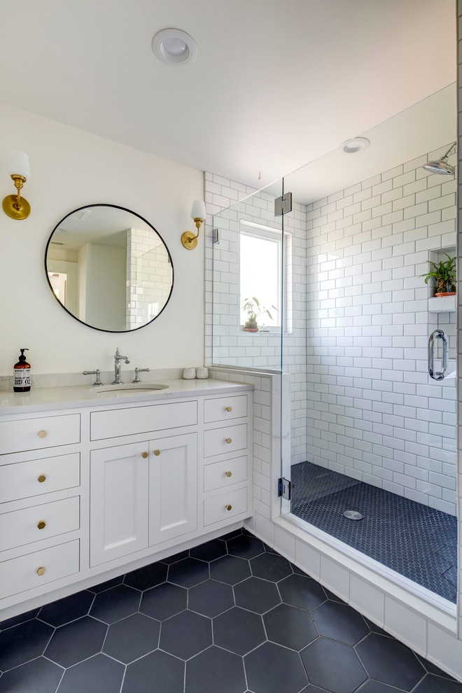 Photo of a large traditional bathroom in Portland with recessed-panel cabinets, white cabinets, an alcove shower, white tile, subway tile, beige walls, porcelain floors, an undermount sink, quartzite benchtops, black floor, a hinged shower door and white benchtops.