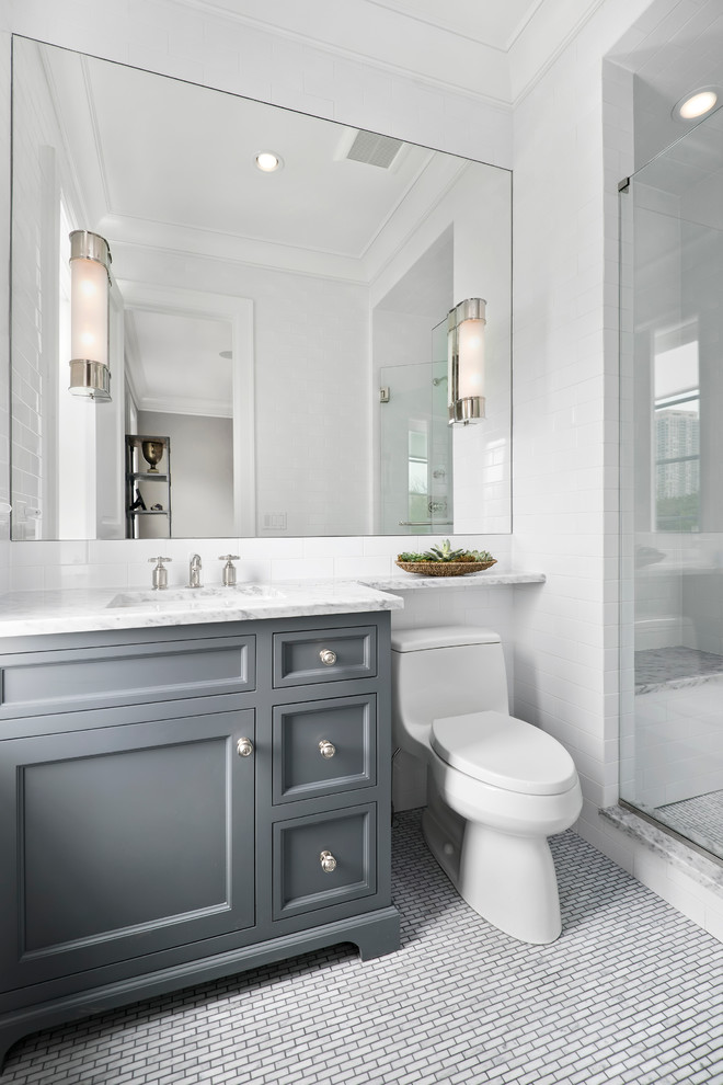 Inspiration for a small transitional bathroom in Chicago with an undermount sink, grey cabinets, marble benchtops, an alcove shower, a one-piece toilet, white tile, stone tile, marble floors and recessed-panel cabinets.