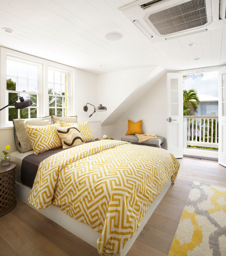 Photo of a beach style master bedroom in Other with white walls, light hardwood floors and beige floor.