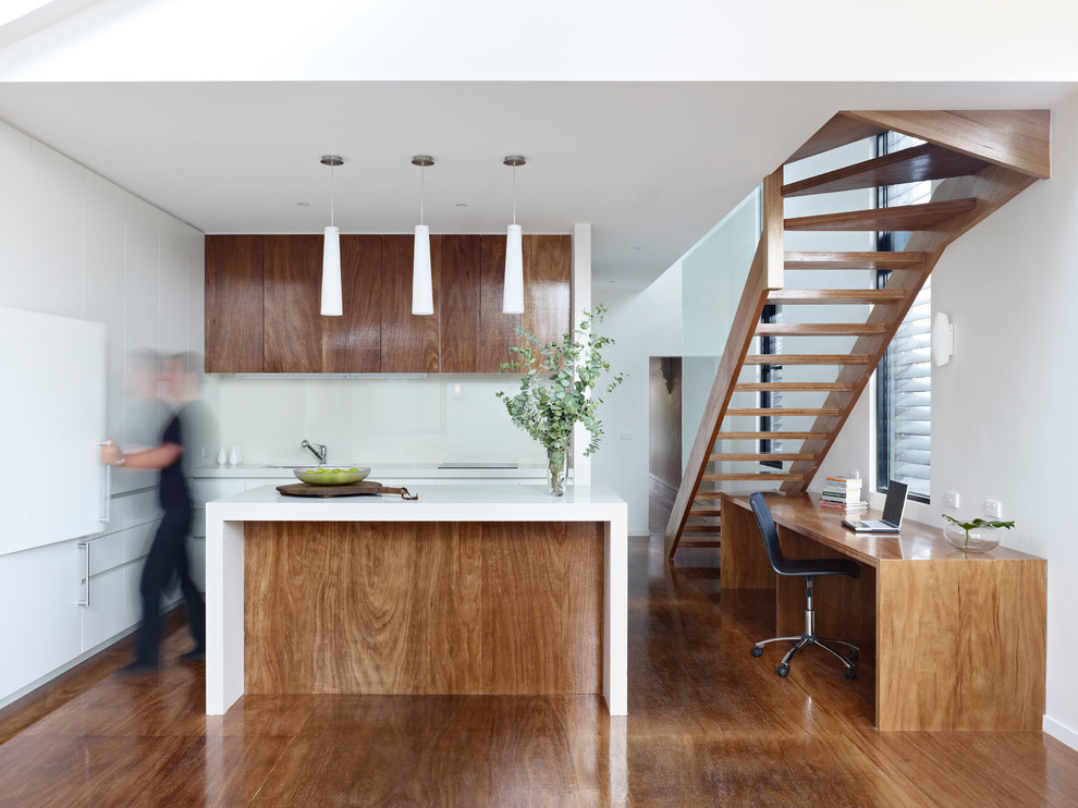 Photo of a small modern galley eat-in kitchen in Melbourne with an undermount sink, flat-panel cabinets, medium wood cabinets, quartz benchtops, white splashback, glass sheet splashback, panelled appliances, medium hardwood floors and with island.