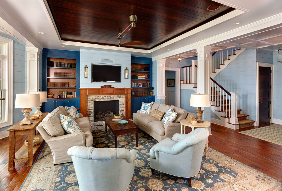 Inspiration for a beach style living room in Charleston with blue walls, medium hardwood floors, a standard fireplace and a brick fireplace surround.