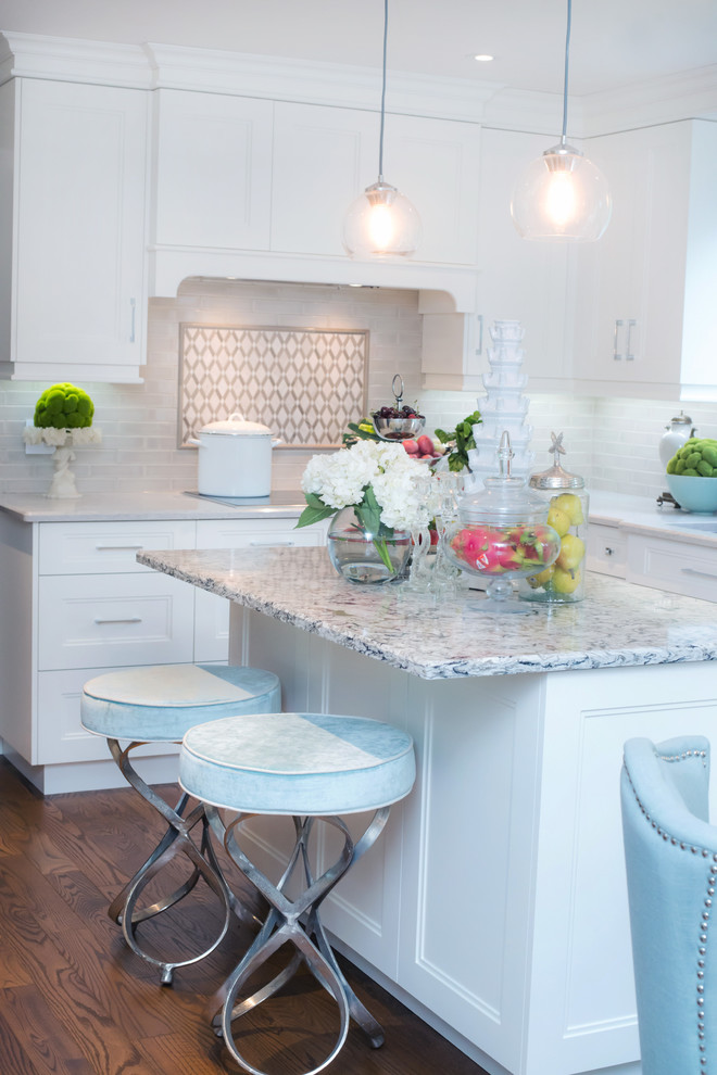 Inspiration for a mid-sized transitional u-shaped eat-in kitchen remodel in Toronto with shaker cabinets, white cabinets, white backsplash, an island, quartz countertops and stainless steel appliances