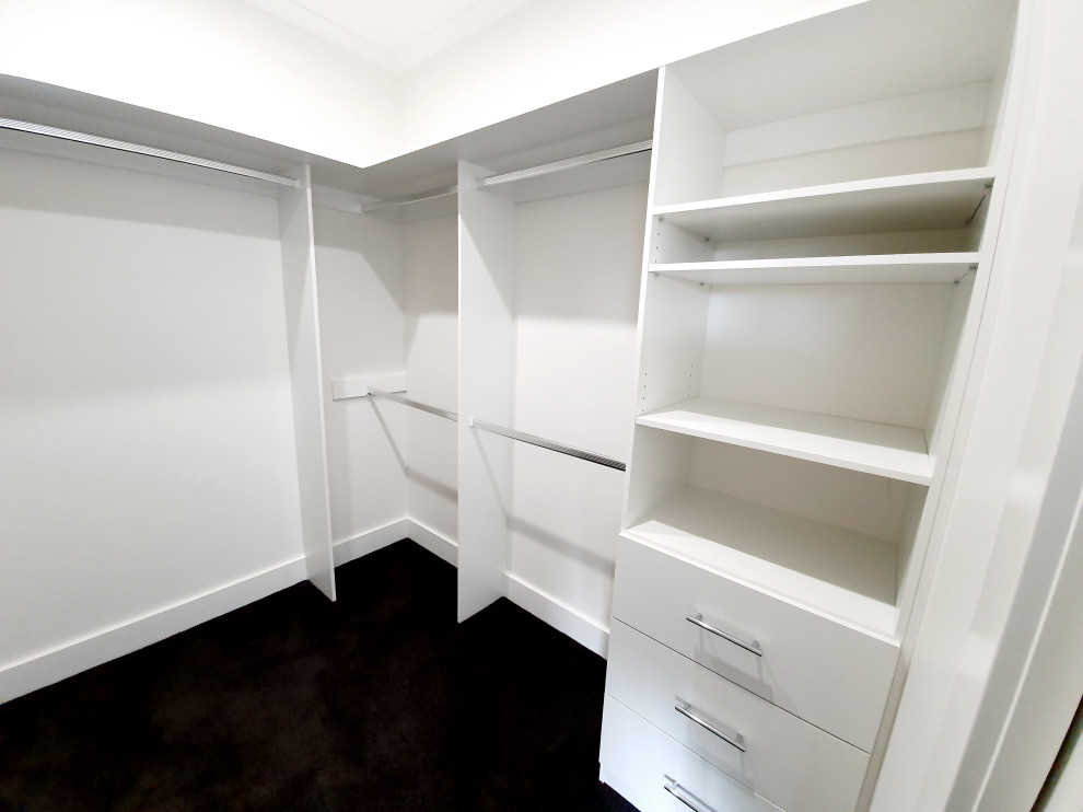 Photo of a mid-sized contemporary walk-in wardrobe in Melbourne with carpet and grey floor.
