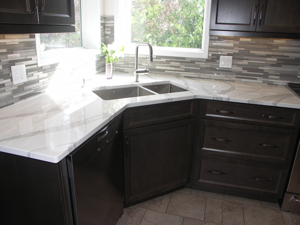 Open concept kitchen - mid-sized transitional u-shaped porcelain tile open concept kitchen idea in Edmonton with an undermount sink, recessed-panel cabinets, dark wood cabinets, quartzite countertops, multicolored backsplash, matchstick tile backsplash, white appliances and two islands
