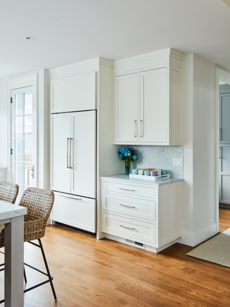 Inspiration for an expansive transitional u-shaped eat-in kitchen in New York with an undermount sink, shaker cabinets, white cabinets, blue splashback, stainless steel appliances, medium hardwood floors, with island, brown floor and grey benchtop.