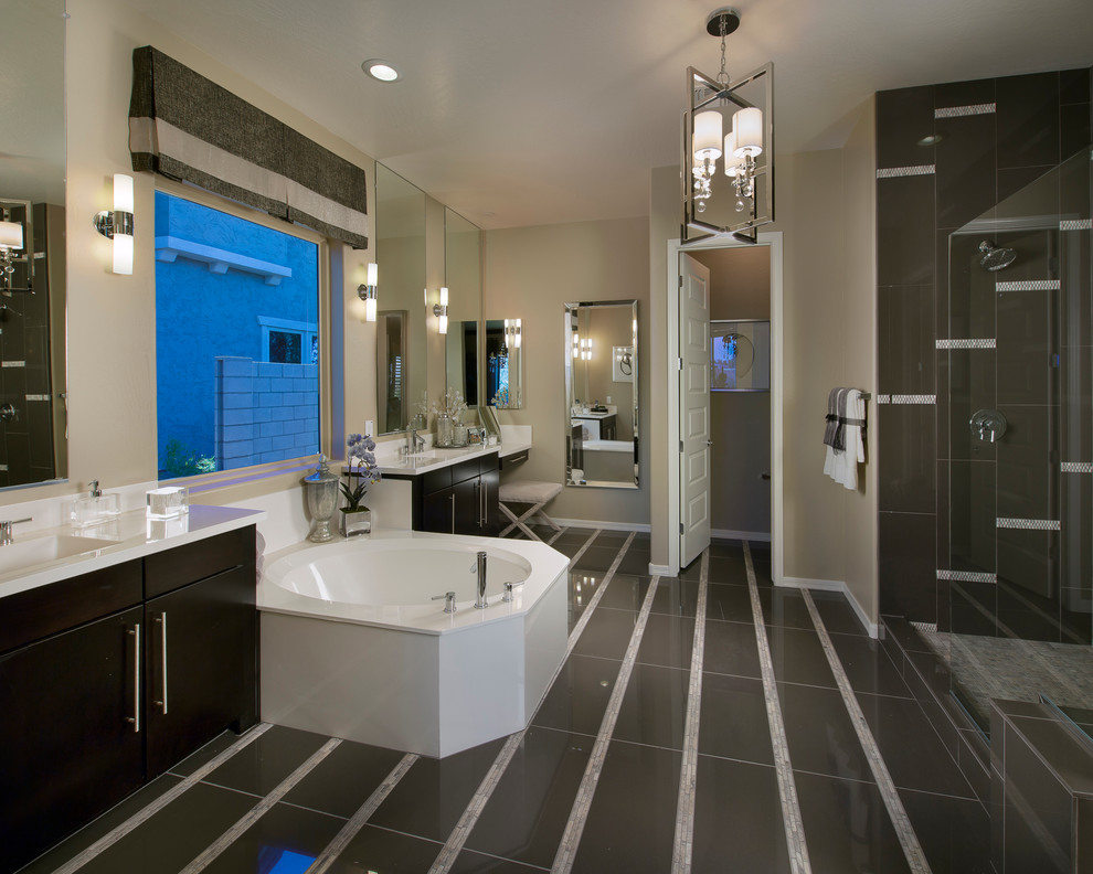This is an example of a transitional bathroom in Phoenix with an integrated sink, flat-panel cabinets, dark wood cabinets, black tile and a drop-in tub.