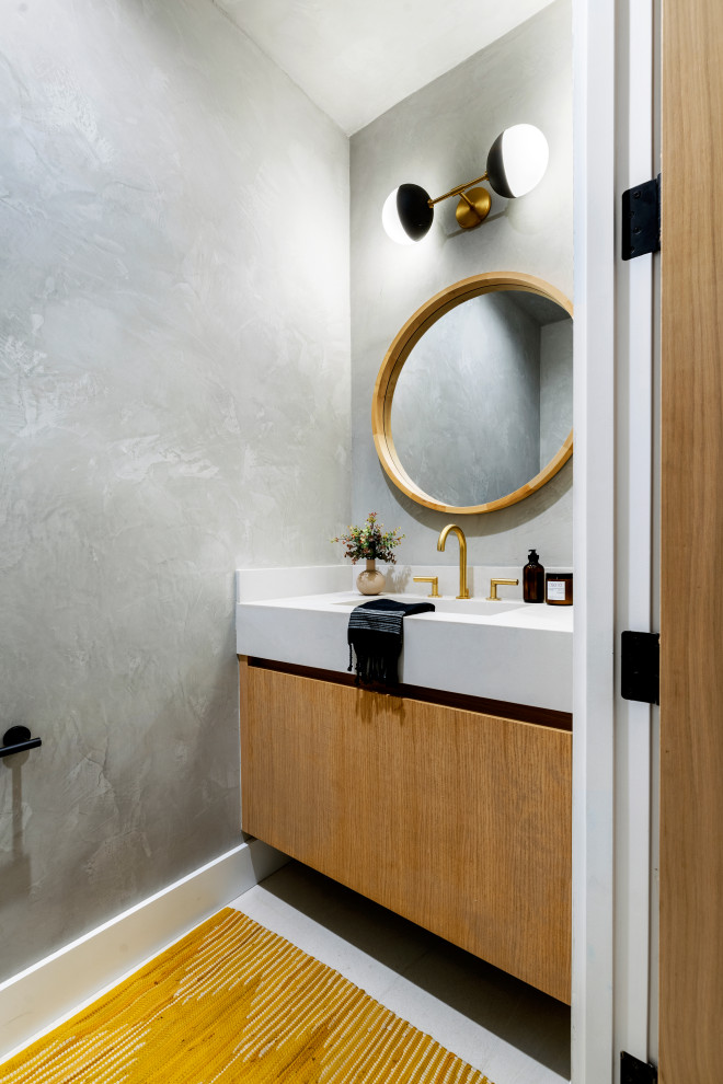 Immagine di un bagno di servizio contemporaneo con ante lisce, ante in legno chiaro, pareti grigie, pavimento con piastrelle in ceramica, lavabo integrato, top in quarzo composito, pavimento bianco, top bianco e mobile bagno sospeso