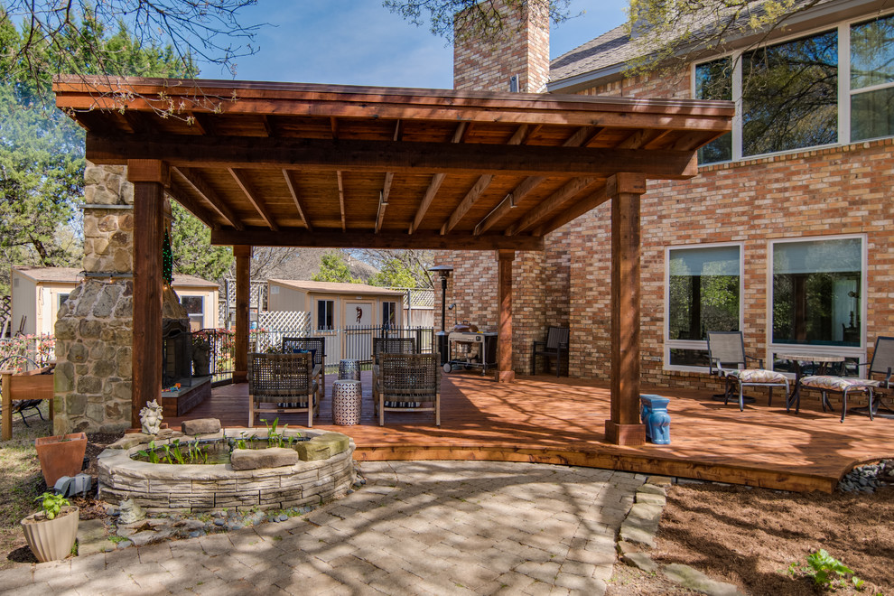 This is an example of a large traditional backyard patio in Dallas with a fire feature, decking and a gazebo/cabana.