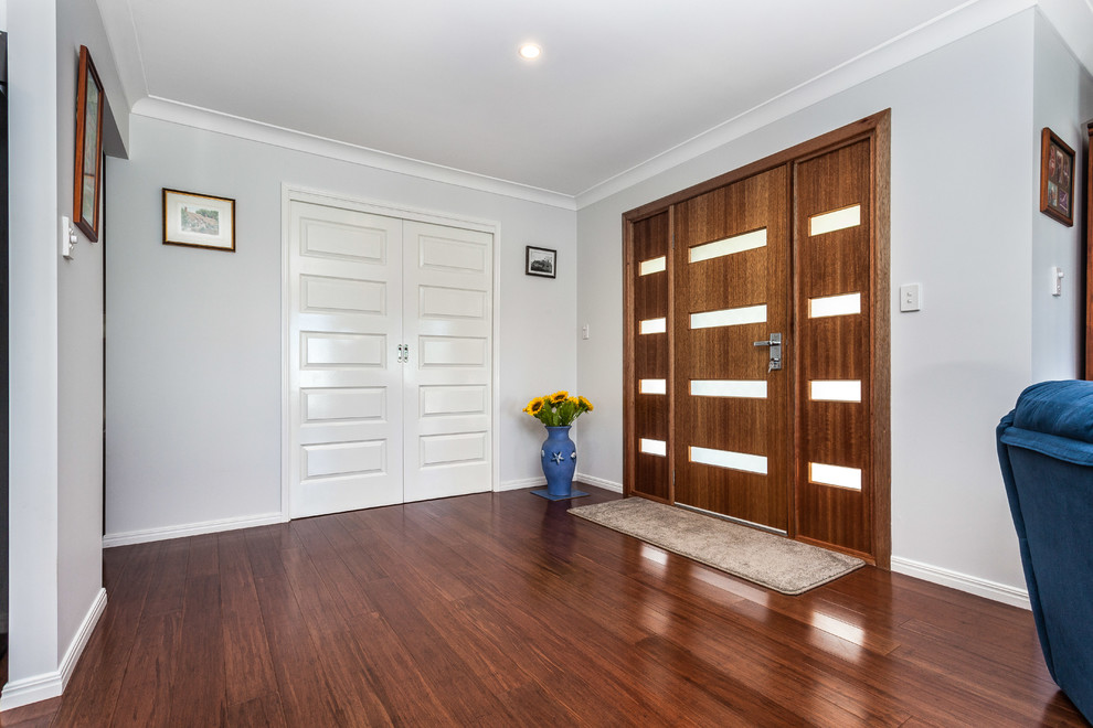 Small transitional front door in Brisbane with grey walls, bamboo floors, a single front door and a medium wood front door.