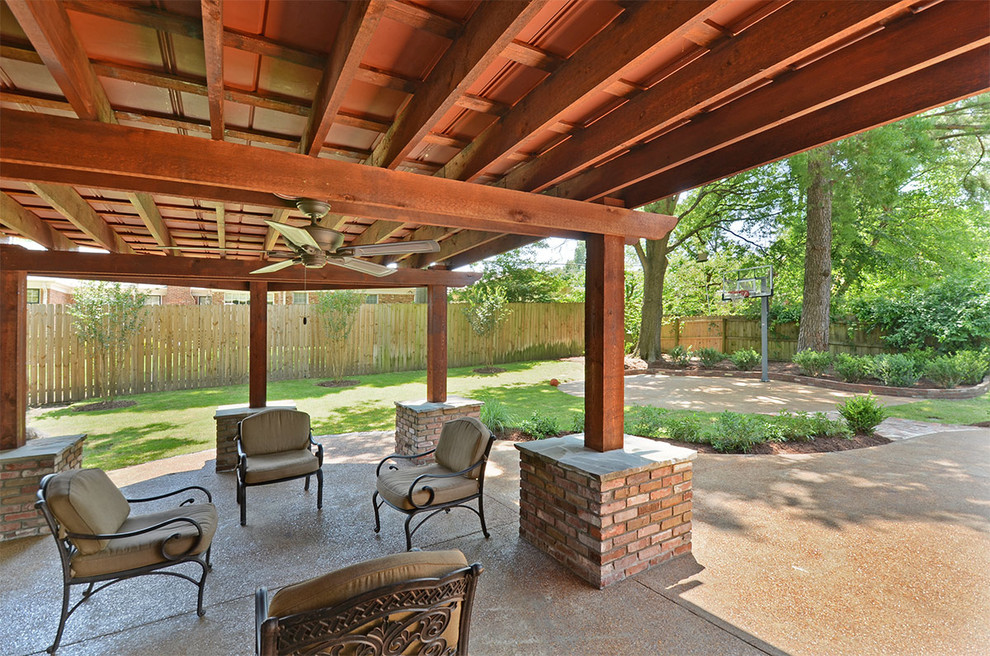 Modelo de patio clásico de tamaño medio en patio trasero con cocina exterior, losas de hormigón y pérgola