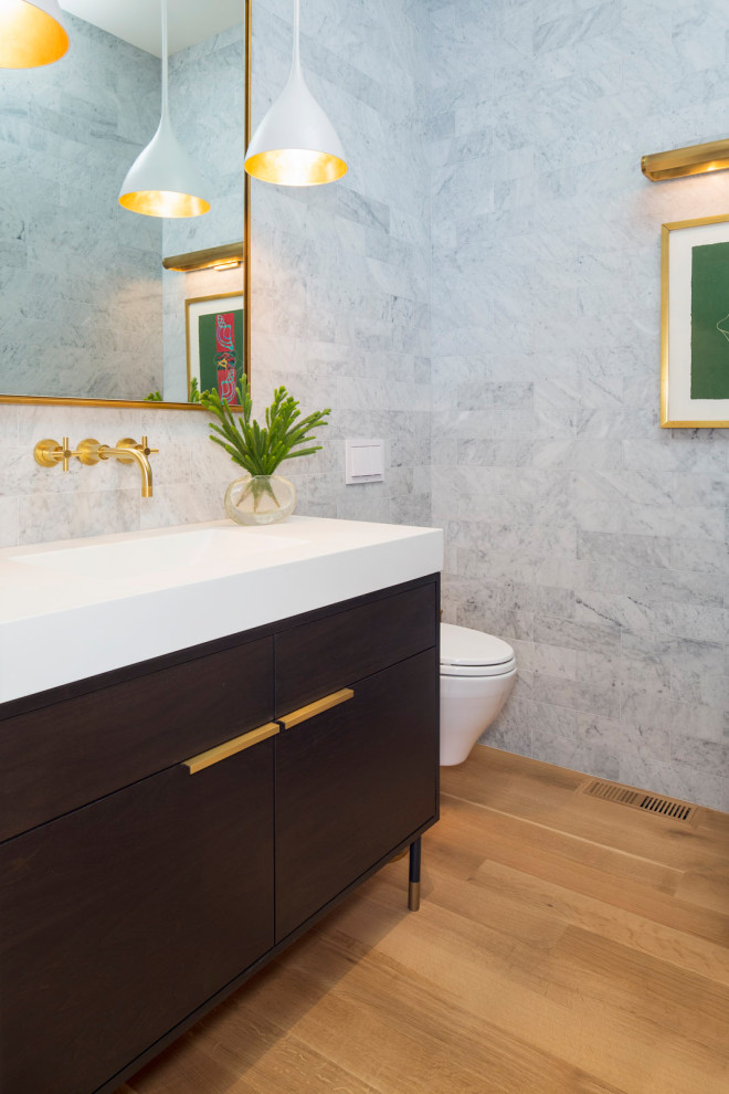 Idée de décoration pour une salle de bain minimaliste en bois foncé de taille moyenne avec un placard à porte plane, WC suspendus, un carrelage gris, un carrelage de pierre, un mur gris, parquet clair, un lavabo encastré, un plan de toilette en surface solide, un sol noir, un plan de toilette blanc, meuble simple vasque et meuble-lavabo sur pied.