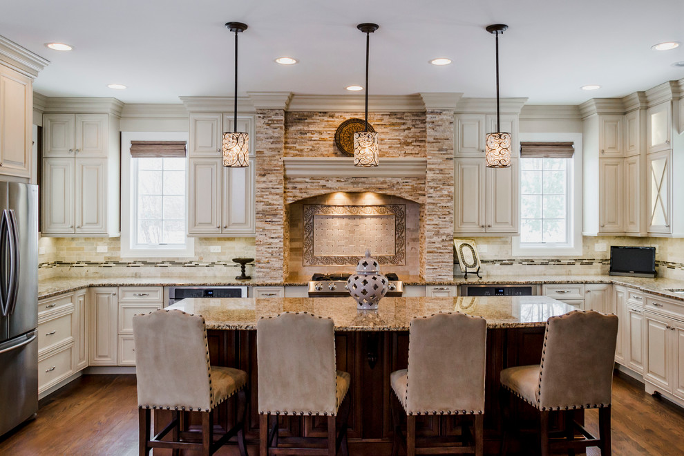 Eat-in kitchen - large transitional u-shaped medium tone wood floor and brown floor eat-in kitchen idea in Chicago with an undermount sink, raised-panel cabinets, white cabinets, granite countertops, multicolored backsplash, subway tile backsplash, stainless steel appliances, beige walls, an island and beige countertops
