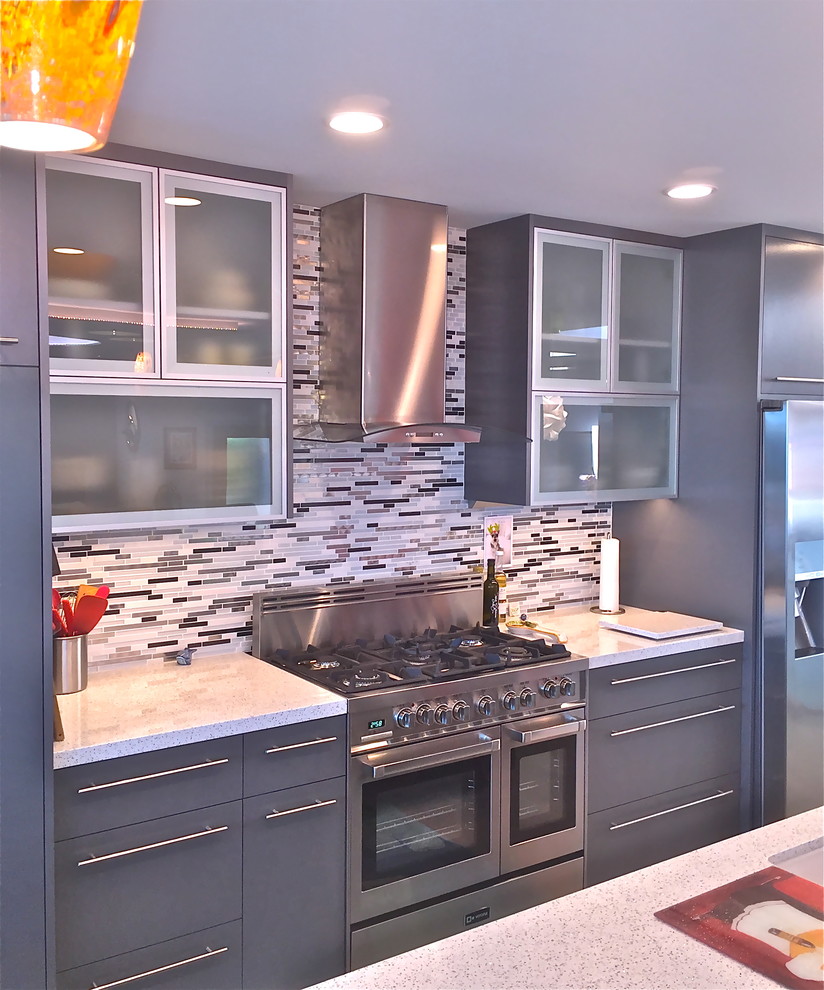 Inspiration for an expansive modern single-wall eat-in kitchen in San Luis Obispo with an undermount sink, glass-front cabinets, grey cabinets, glass benchtops, multi-coloured splashback, glass tile splashback, stainless steel appliances, medium hardwood floors and with island.