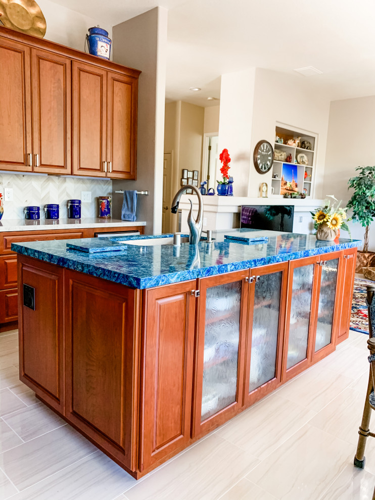 Photo of a large traditional l-shaped open plan kitchen in San Francisco with a single-bowl sink, raised-panel cabinets, red cabinets, quartz benchtops, beige splashback, porcelain splashback, stainless steel appliances, porcelain floors, with island, beige floor and blue benchtop.