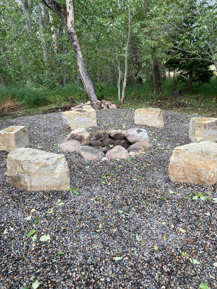 This is an example of a mid-sized country backyard outdoor sport court in Other with a fire feature and gravel.