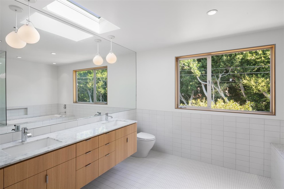 Photo of a midcentury bathroom in Los Angeles with an undermount sink, flat-panel cabinets, light wood cabinets, white tile, white walls and mosaic tile floors.