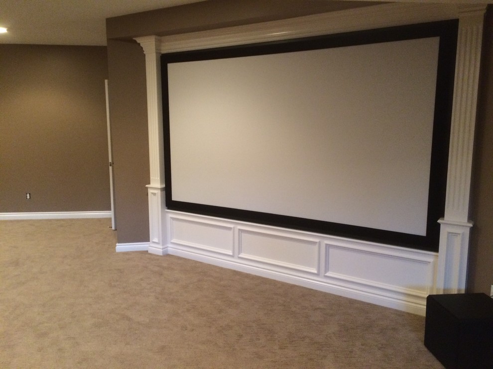 This is an example of a mid-sized traditional open concept home theatre in Detroit with brown walls, carpet and a projector screen.