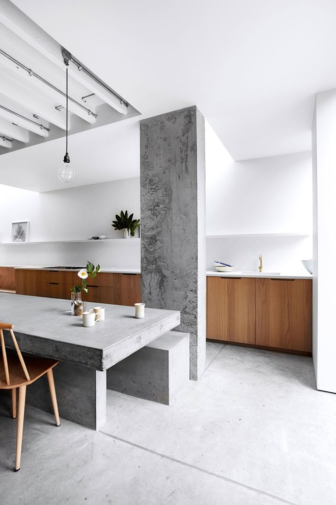 Photo of a small midcentury single-wall eat-in kitchen in Toronto with flat-panel cabinets, medium wood cabinets, quartzite benchtops, white splashback, concrete floors, grey floor and white benchtop.